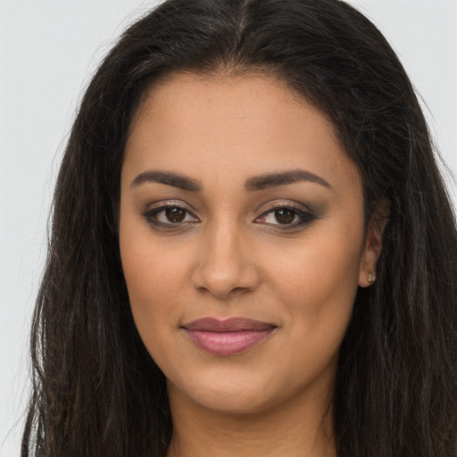 Joyful latino young-adult female with long  brown hair and brown eyes