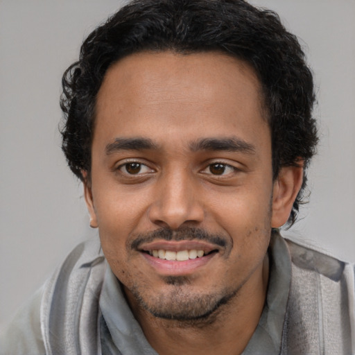 Joyful latino young-adult male with short  black hair and brown eyes