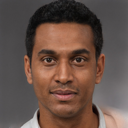 Joyful black adult male with short  black hair and brown eyes
