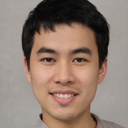 Joyful asian young-adult male with short  black hair and brown eyes