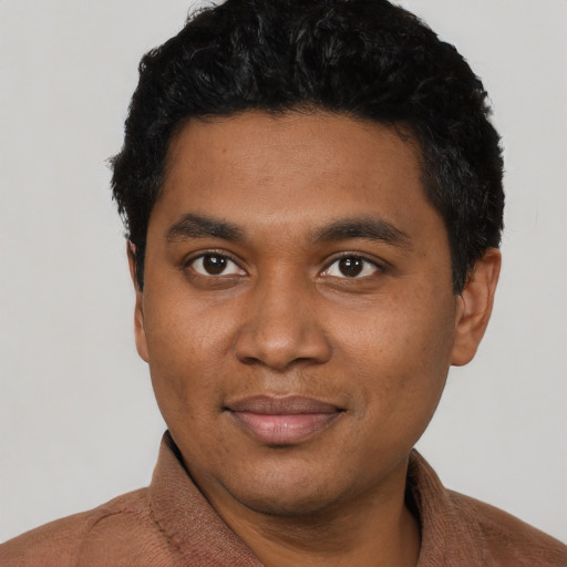 Joyful black young-adult male with short  black hair and brown eyes