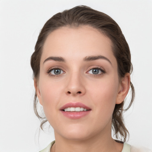 Joyful white young-adult female with medium  brown hair and grey eyes