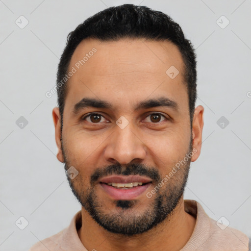 Joyful latino young-adult male with short  black hair and brown eyes