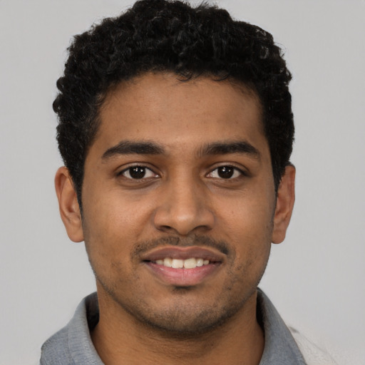 Joyful black young-adult male with short  black hair and brown eyes