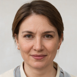 Joyful white adult female with medium  brown hair and grey eyes