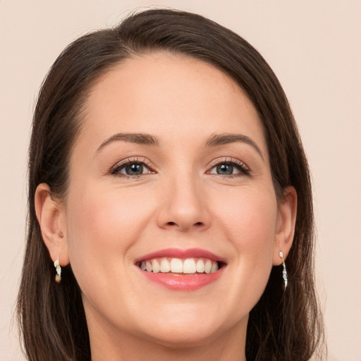 Joyful white young-adult female with long  brown hair and grey eyes