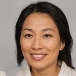 Joyful asian adult female with medium  brown hair and brown eyes