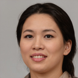 Joyful asian young-adult female with medium  brown hair and brown eyes