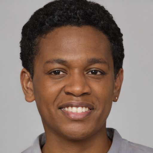 Joyful black young-adult male with short  black hair and brown eyes