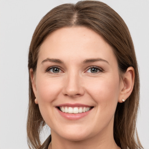 Joyful white young-adult female with medium  brown hair and grey eyes