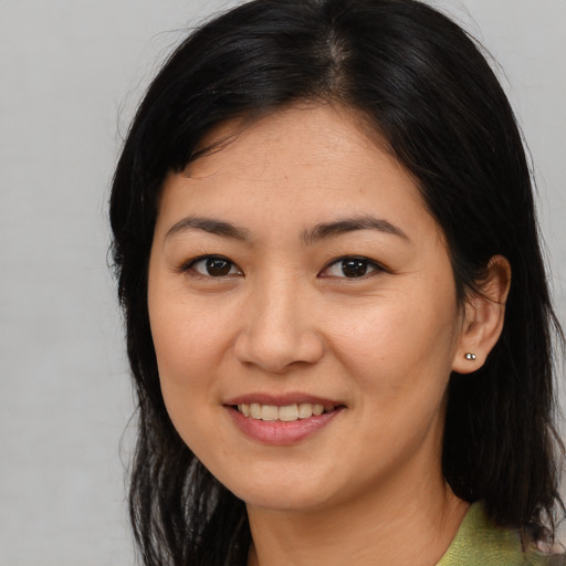Joyful asian young-adult female with long  brown hair and brown eyes