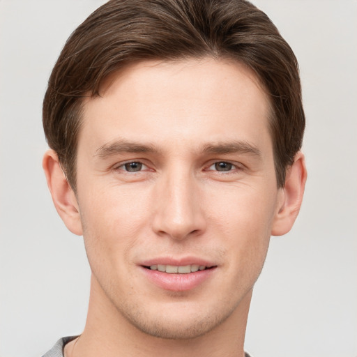 Joyful white young-adult male with short  brown hair and grey eyes