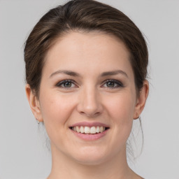 Joyful white young-adult female with medium  brown hair and grey eyes