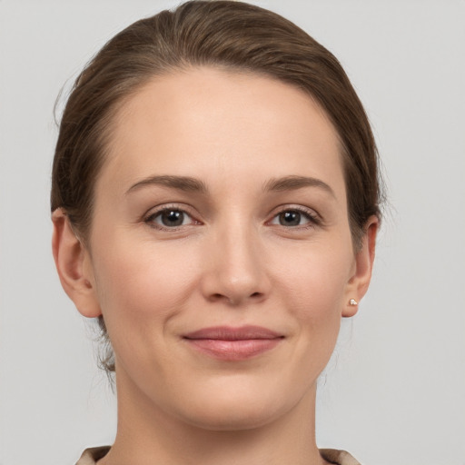 Joyful white young-adult female with medium  brown hair and grey eyes