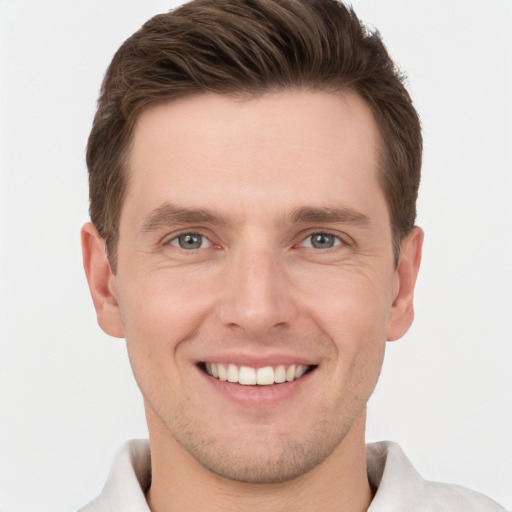 Joyful white young-adult male with short  brown hair and grey eyes