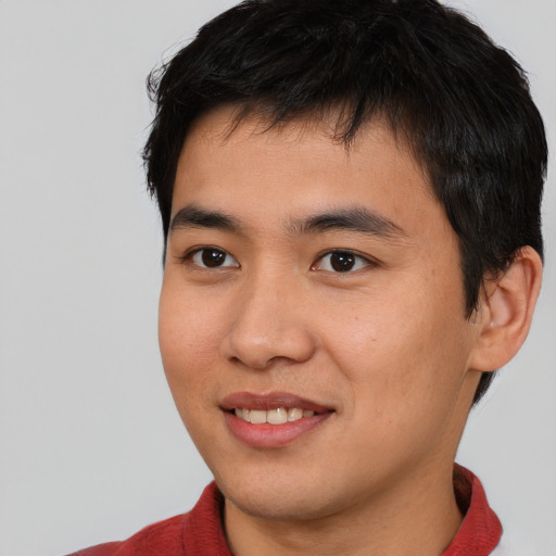 Joyful asian young-adult male with short  brown hair and brown eyes