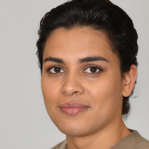 Joyful latino young-adult female with short  black hair and brown eyes