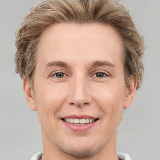 Joyful white adult male with short  brown hair and grey eyes