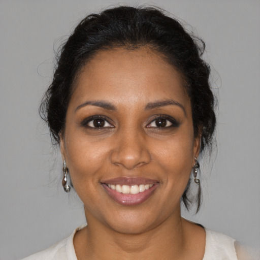 Joyful black young-adult female with medium  brown hair and brown eyes