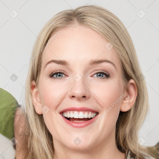 Joyful white young-adult female with medium  brown hair and blue eyes