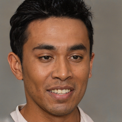 Joyful latino young-adult male with short  brown hair and brown eyes