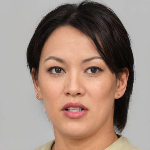 Joyful asian young-adult female with medium  brown hair and brown eyes