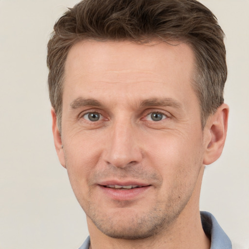 Joyful white adult male with short  brown hair and grey eyes