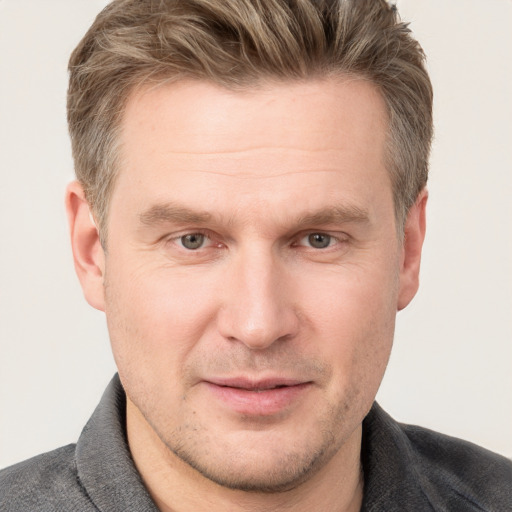 Joyful white adult male with short  brown hair and grey eyes