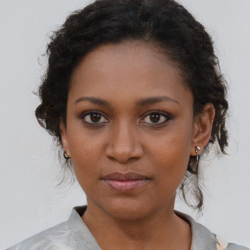 Joyful black young-adult female with short  brown hair and brown eyes