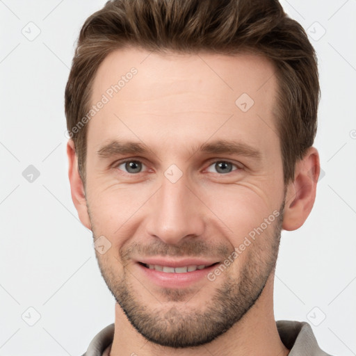 Joyful white young-adult male with short  brown hair and grey eyes