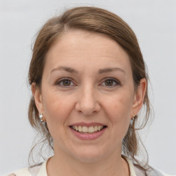 Joyful white adult female with medium  brown hair and grey eyes