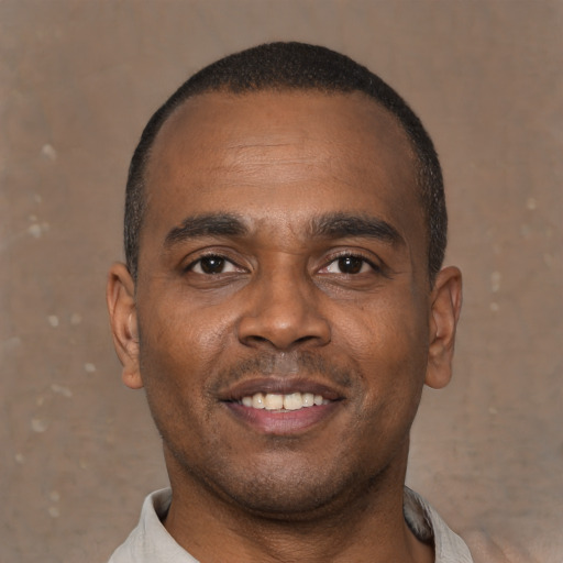 Joyful latino young-adult male with short  brown hair and brown eyes
