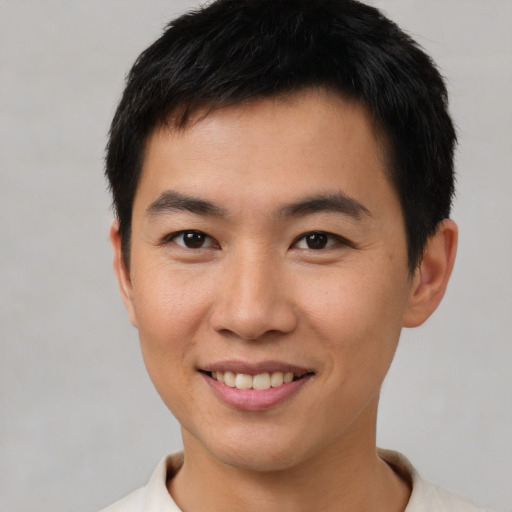 Joyful asian young-adult male with short  brown hair and brown eyes