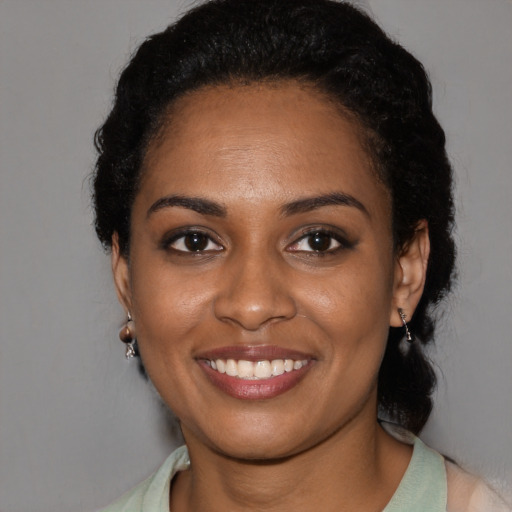 Joyful black young-adult female with short  black hair and brown eyes
