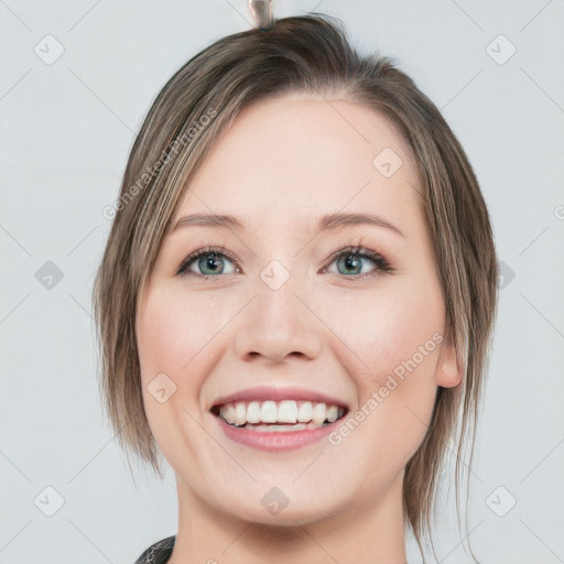 Joyful white young-adult female with medium  brown hair and blue eyes