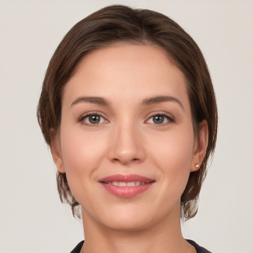 Joyful white young-adult female with medium  brown hair and grey eyes