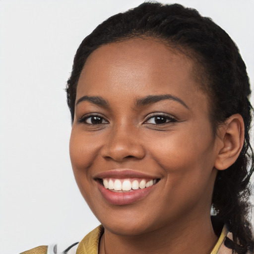 Joyful black young-adult female with long  brown hair and brown eyes