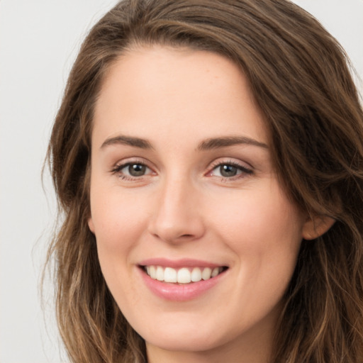 Joyful white young-adult female with long  brown hair and green eyes