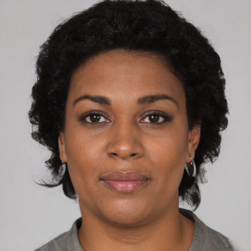 Joyful black young-adult female with short  black hair and brown eyes