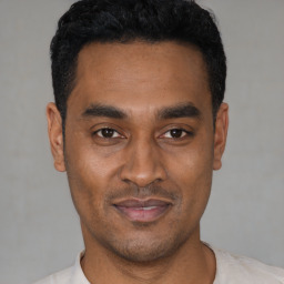 Joyful latino young-adult male with short  black hair and brown eyes