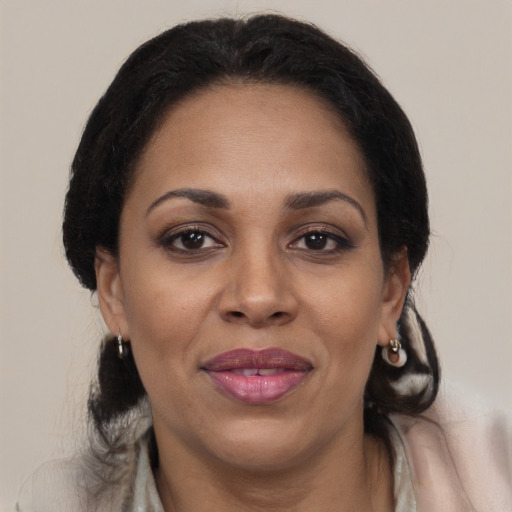 Joyful black adult female with medium  brown hair and brown eyes