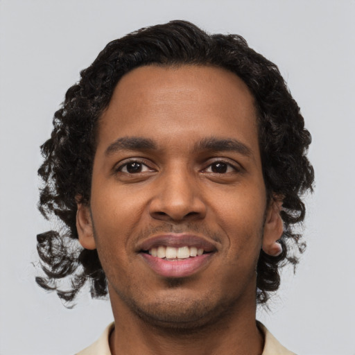 Joyful black young-adult male with short  brown hair and brown eyes
