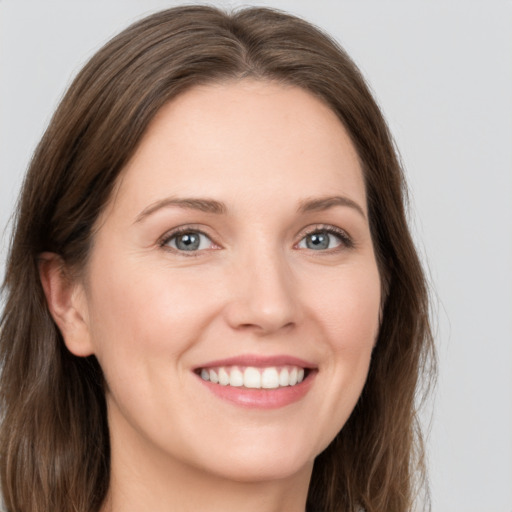 Joyful white young-adult female with long  brown hair and grey eyes