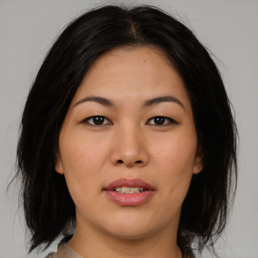 Joyful asian young-adult female with medium  brown hair and brown eyes