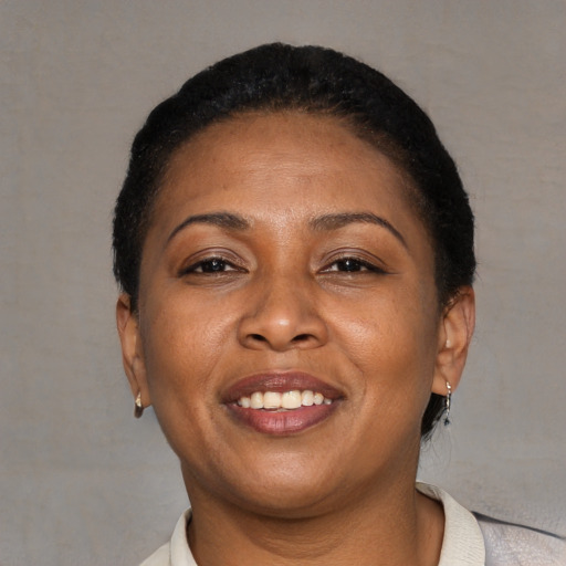Joyful black adult female with short  black hair and brown eyes