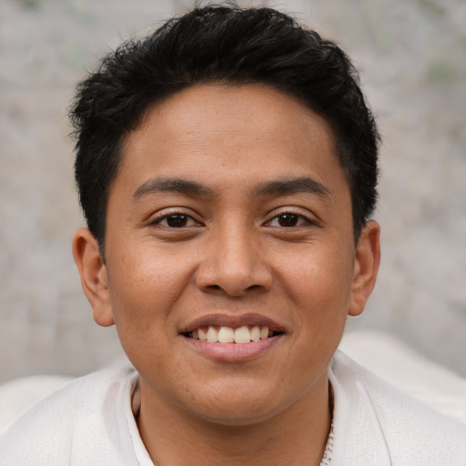 Joyful latino young-adult male with short  brown hair and brown eyes