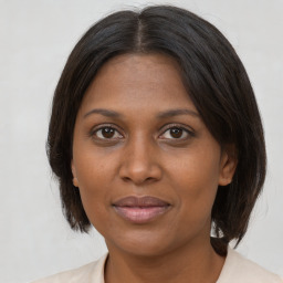 Joyful black adult female with medium  brown hair and brown eyes