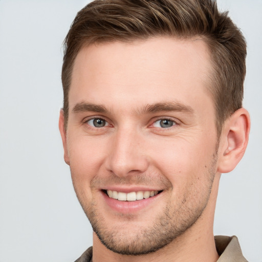 Joyful white young-adult male with short  brown hair and grey eyes