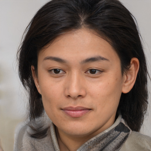 Joyful asian young-adult female with medium  brown hair and brown eyes