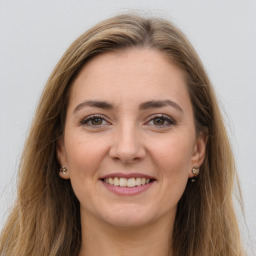 Joyful white young-adult female with long  brown hair and grey eyes